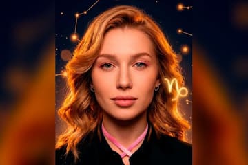 Портрет Кати Вяликовой крупным планом на фоне тёмно-синего звёздного неба с созвездиями и золотым глифом Козерога — иллюстрация к разбору её натальной карты